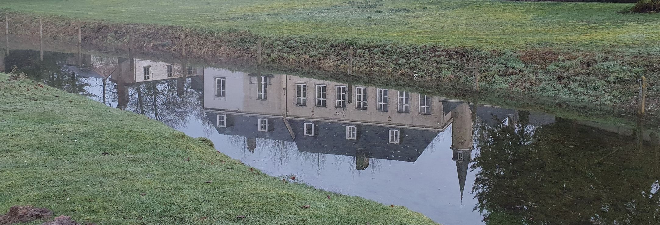 Uitzicht op de gracht van het Château de la Saulinière met een weerspiegeling van het kasteel